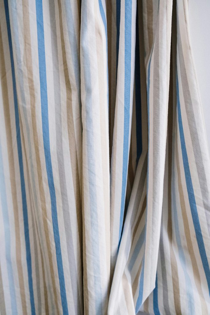 Detailed view of a blue and beige striped curtain fabric, perfect for interior design inspiration.
